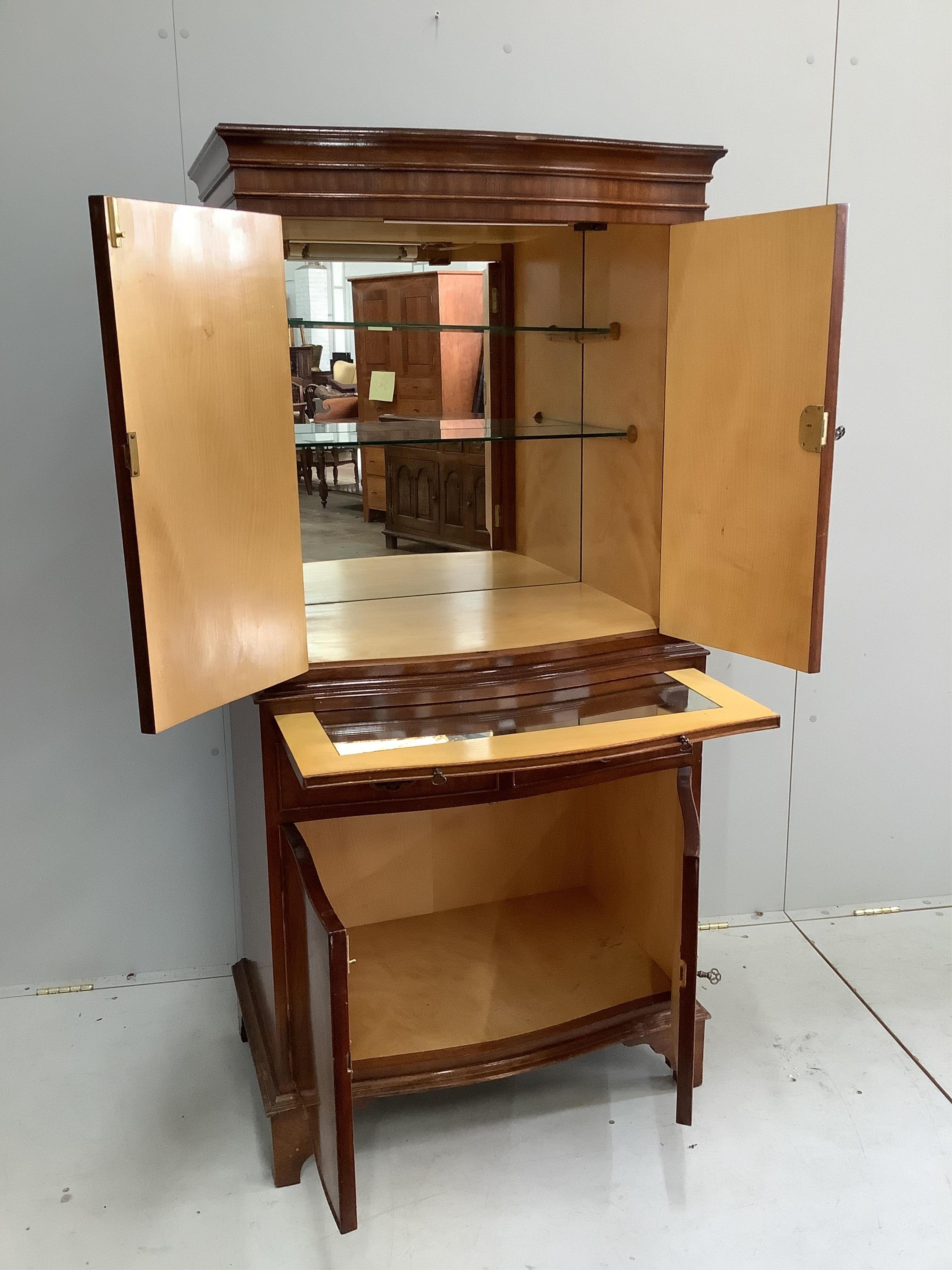 A reproduction serpentine mahogany cocktail cabinet, width 72cm, depth 46cm, height 153cm. Condition - fair